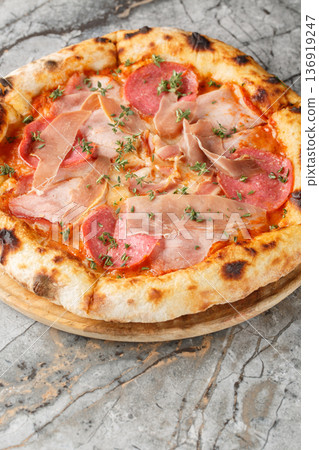 Italian four meat pizza with prosciutto, salami, bacon and ham close-up on a wooden board. Vertical Italian four meat pizza with prosciutto, salami, bacon and ham close-up on a wooden board. Vertical 136919247