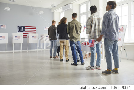Large diverse group of people registering at polling station holding American flags on election day Large diverse group of people registering at polling station holding American flags on election day 136919335