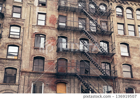Rusty fire escapes on an old brick building. Rusty fire escapes on an old brick building. 136919507
