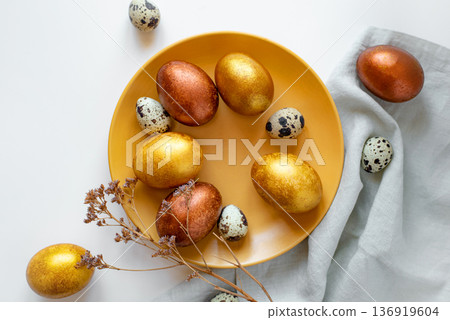 Golden and bronze Easter eggs in a orange plate Golden and bronze Easter eggs in a orange plate 136919604