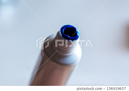 A close-up view of a tube of blue paint with a slightly opened nozzle. The vibrant blue color is visible at the tip, ready for use in artistic projects. 136919657