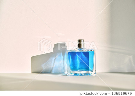 Blue fragrance bottle casting shadow on wall Blue fragrance bottle casting shadow on wall 136919679
