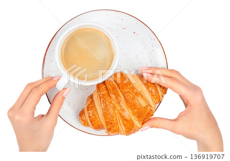Female hands holding croissant and coffee cup on plate isolated on white background 136919707