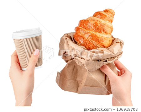 Takeaway coffee and croissant in paper bag held by woman 136919708