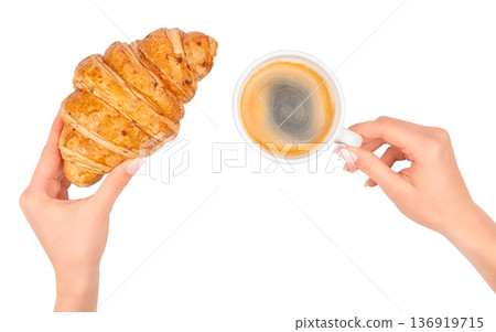 Female hands holding croissant and cup of coffee isolated on white background 136919715