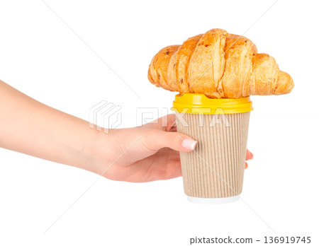 Woman holding takeaway coffee cup with croissant on top Woman holding takeaway coffee cup with croissant on top 136919745