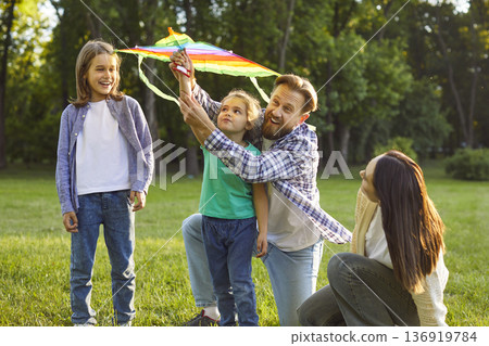 Happy Caucasian father play kite with two kids during family leisure outdoors Happy Caucasian father play kite with two kids during family leisure outdoors 136919784