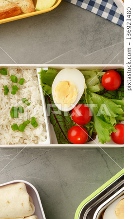 Lunch box with rice, boiled egg, salad, and cherry tomatoes in a simple layout Lunch box with rice, boiled egg, salad, and cherry tomatoes in a simple layout 136921480