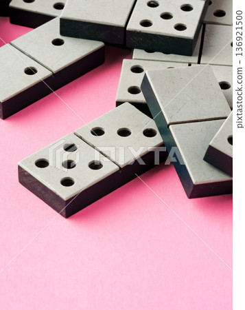 Dominoes arranged on a pink background for a gaming activity in a casual setting 136921500
