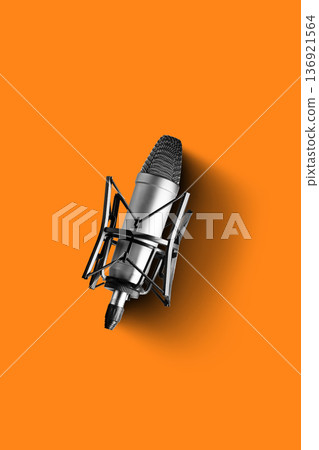 Podcast microphone on an orange background for recording discussions and interviews 136921564