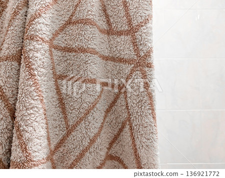 Soft beige towel hanging at bathroom, geometric design, sense of comfort and warmth. Decorative element for home organization, interior design, cozy indoor 136921772