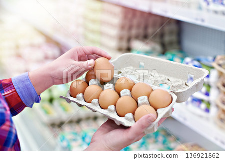 Hands with packing eggs in shop Hands with packing eggs in shop 136921862
