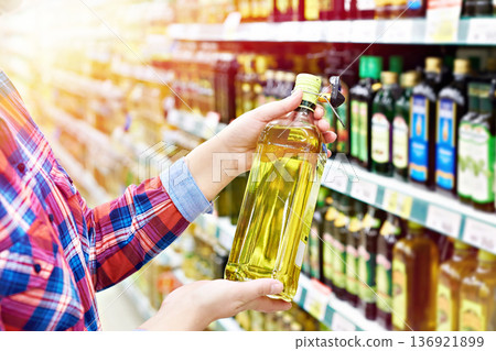 Buyer with sunflower oil in shop Buyer with sunflower oil in shop 136921899