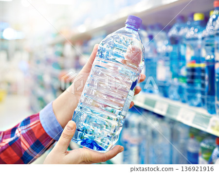 Buyer with bottle water in shop Buyer with bottle water in shop 136921916