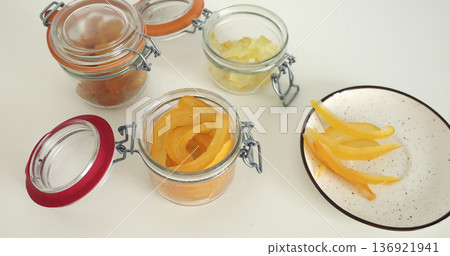Preparing candied citrus fruits for jars. Sweets and traditional food in Italy. Kumquats, orange peels, and citron. Seasonal, high-quality European farm products. Preparing candied citrus fruits for jars. Sweets and traditional food in Italy. Kumquats, orange peels, and citron. Seasonal, high-quality European farm products. 136921941