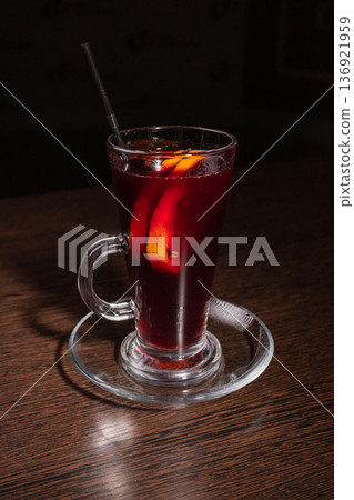 Mulled wine in a glass on a wooden table 136921959