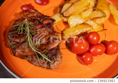 Steak with fried potatoes and tomatoes on a plate 136921981