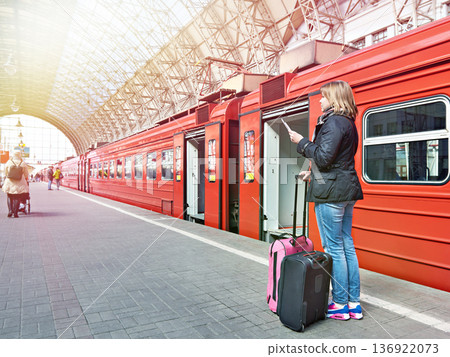 Woman with suitcases near train on station 136922073