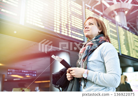 Woman tourist in airport on board of departures and arrivals Woman tourist in airport on board of departures and arrivals 136922075