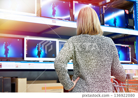Woman at LCD TVs in shop Woman at LCD TVs in shop 136922080