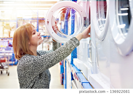 Woman chooses washing machine in shop Woman chooses washing machine in shop 136922081