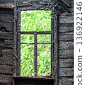 Charred wooden window frame of a burned down house. Burnt broken wood wall 136922146