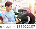 Man chooses winter studded tires for car 136922157