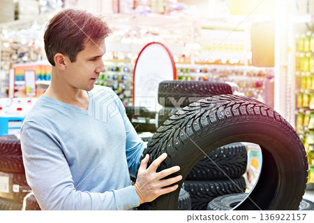Man chooses winter studded tires for car 136922157