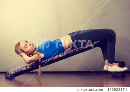 Woman training on bench for sit ups 136922174