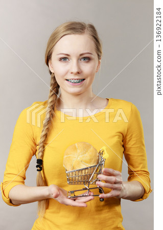 Woman holding shopping cart with bread Woman holding shopping cart with bread 136922184