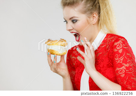 Funny woman holds cream puff cake Funny woman holds cream puff cake 136922256