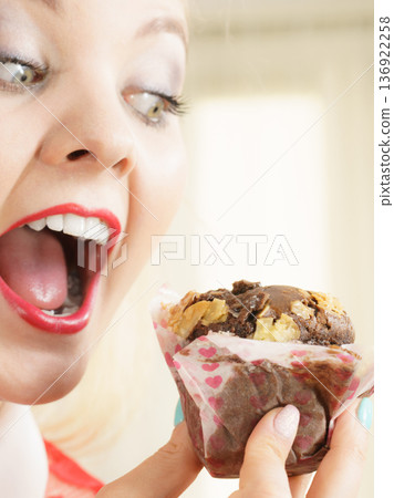 Attractive woman holds cake in hand Attractive woman holds cake in hand 136922258
