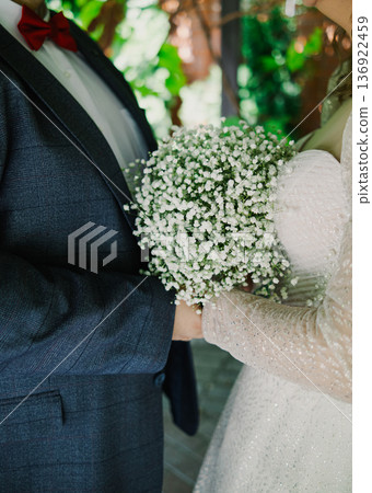 The bride and groom are holding a wedding bouquet The bride and groom are holding a wedding bouquet 136922459