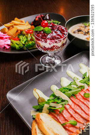 A plate with sliced red fish, bread and greens A plate with sliced red fish, bread and greens 136922595
