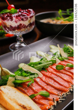A plate with sliced red fish, bread and greens A plate with sliced red fish, bread and greens 136922596
