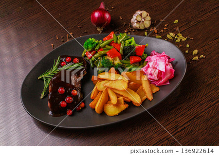 A plate of fried meat, fried potatoes and 136922614