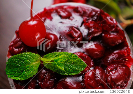 Dessert of pickled cherries with cream in a glass 136922648