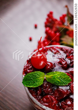 Dessert of pickled cherries with cream in a glass 136922650