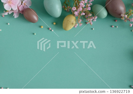 Pastel Easter Eggs and Flowers on Teal Background. Festive Spring Flatlay 136922719