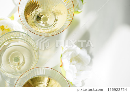 Champagne Glasses with White Peonies. Birthday or Wedding Celebration Arrangement. Top view Champagne Glasses with White Peonies. Birthday or Wedding Celebration Arrangement. Top view 136922734
