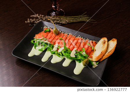 A plate with sliced red fish, bread and greens A plate with sliced red fish, bread and greens 136922777