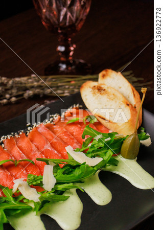 A plate with sliced red fish, bread and greens A plate with sliced red fish, bread and greens 136922778