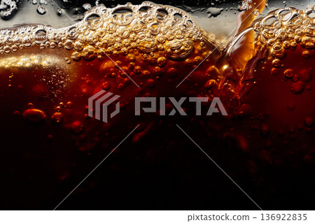 Coffee is poured into a glass with ice. 136922835