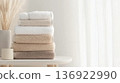 Neutral colors stacked towels by window on minimalistic background, copy space 136922990