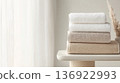 Neutral colors stacked towels by window on minimalistic background, copy space 136922993