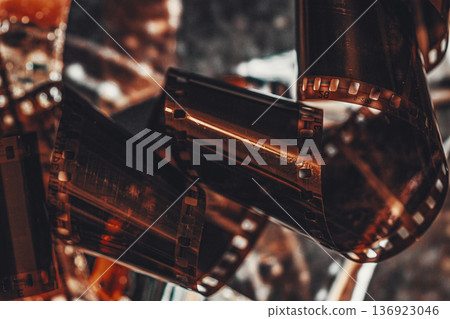 Old film strip close up with scratches, noise texture in retro style, analog roll of photographic film frames. Concept of nostalgia, media archive, vintage cinematic background Old film strip close up with scratches, noise texture in retro style, analog roll of photographic film frames. Concept of nostalgia, media archive, vintage cinematic background 136923046