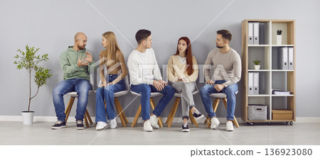 Group of young people talking while waiting for business meeting or job interview 136923080