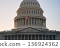 Last beams of golden sunlight on the United States Capitol Building in Washington, DC, with the American flag waving. Dramatic view 136924362