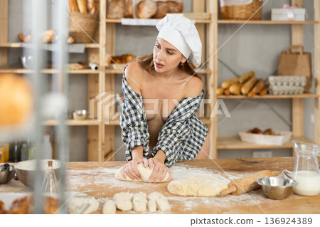 Alluring naked woman in open plaid shirt kneading dough Alluring naked woman in open plaid shirt kneading dough 136924389