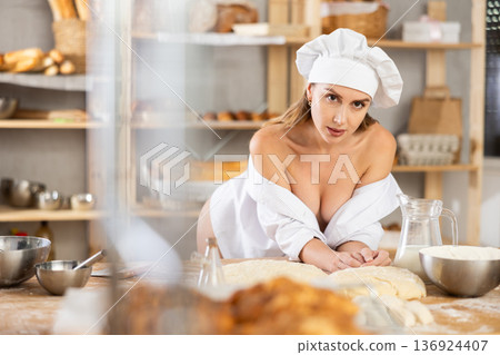 Woman in unbuttoned chef uniform posing in workshop 136924407